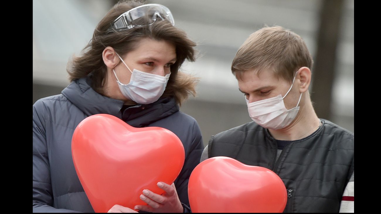 Ucrania: Una pareja con sus barbijos caminan con sus globos de corazón