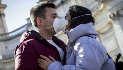 Italia: Una pareja se besa con sus barbijos puestos en los comienzos de la pandemia