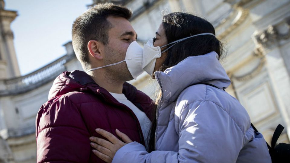 Italia: Una pareja se besa con sus barbijos puestos en los comienzos de la pandemia