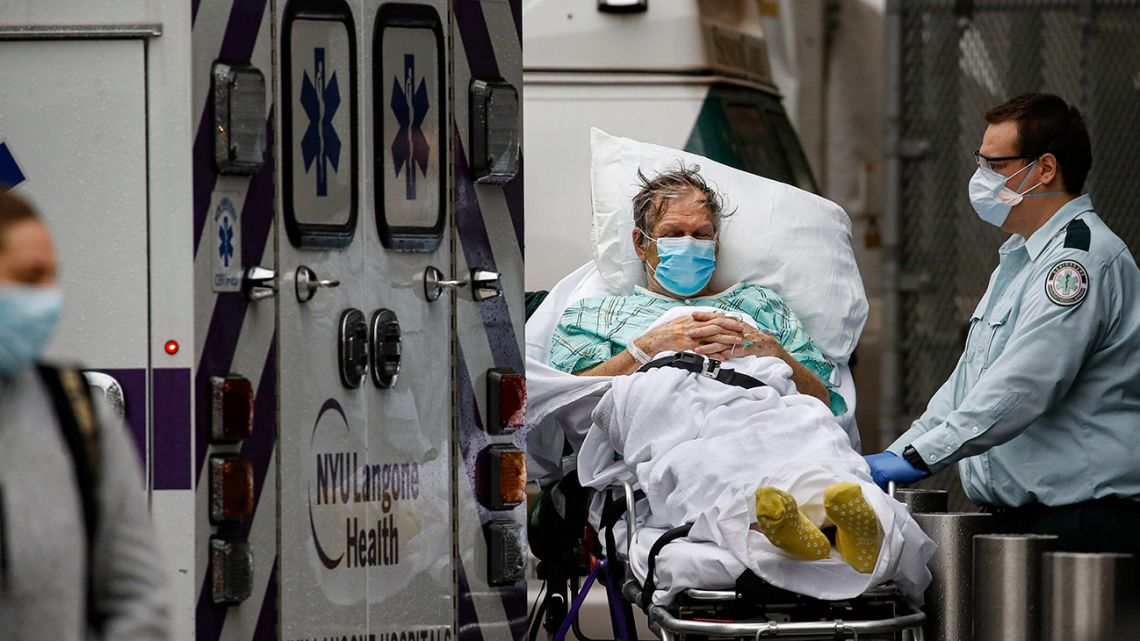 Patients and medical workers wear personal protective equipment due to Covid-19 concerns outside the emergency room at NYU Langone Medical Center, Monday, April 13, 2020, in New York.