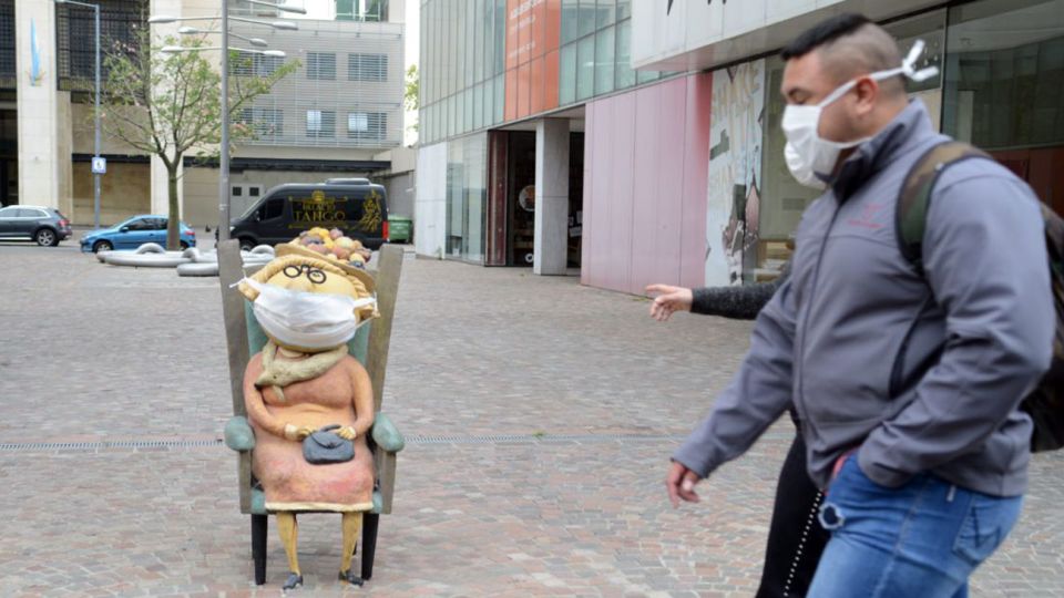 Estatuas y gente con barbijos an te la obligatoriedad del uso en la Ciudad de Buenos Aires