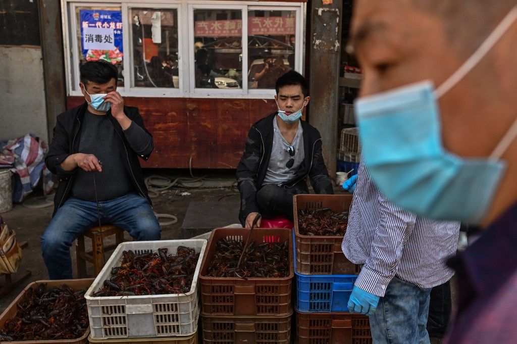 En un gran mercado de alimentos en la ciudad china de Wuhan los carteles prohíben la venta de animales salvajes y aves de corral, mientras los altavoces reproducen una y otra vez mensajes que celebran la "victoria" sobre el nuevo coronavirus.