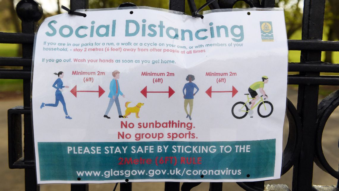Signs on the gates advise people of social distancing rules in Queen's Park in Glasgow on April 16, 2020 as Britain continues to enforce a nationwide lockdown in an effort to halt the spread of the novel coronavirus. 