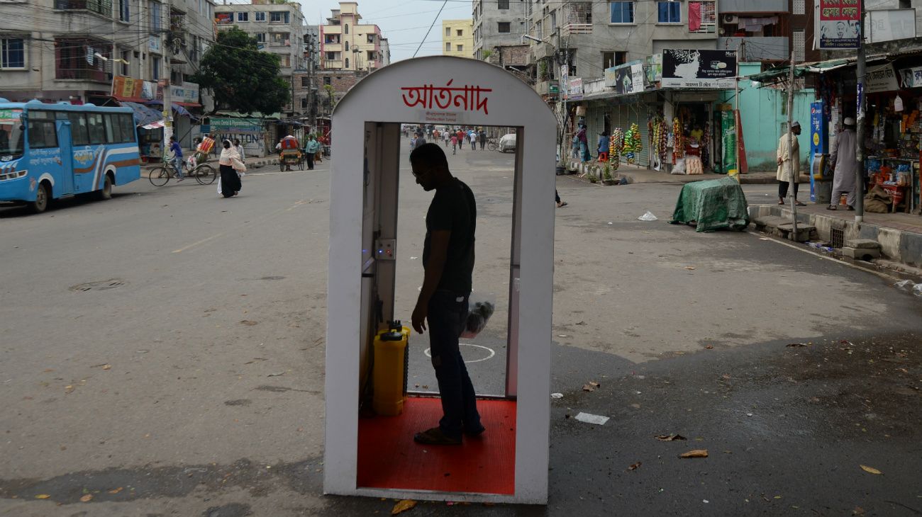 Dhaka, Bangladesh: Un hombre atraviesa un túnel desinfectante 