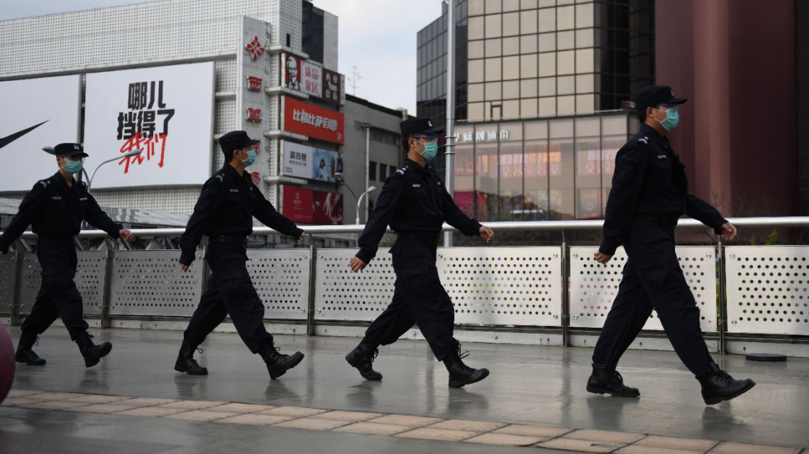 Security guards wear masks amid concerns over the COVID-19 coronavirus, as they patrol outside a shopping mall in Beijing on April 17, 2020.