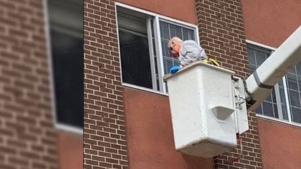 El momento en que el hombre llega con la grúa a la ventana donde esta su mujer.
