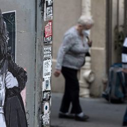 una pareja de ancianos enmascarados caminando junto a un collage del artista francés Combo en París, el 21 de abril de 2020, mientras el país está bajo bloqueo para detener la propagación de la pandemia de Covid-19 causada por el nuevo coronavirus. (Foto por JOEL SAGET / AFP). | Foto:afp