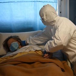 Un trabajador de salud que usa equipo de protección cuida a un paciente en la unidad de cuidados intensivos de nivel, que trata a pacientes con COVID-19, en el hospital San Filippo Neri en Roma, el 20 de abril de 2020, durante el cierre del país destinado a detener la propagación de la pandemia de COVID-19. (Foto por Alberto PIZZOLI / AFP) | Foto:afp