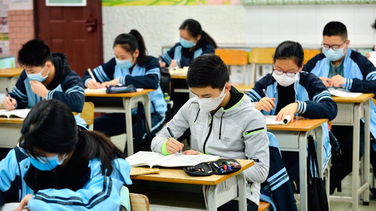 En China, controles de temperatura y distancia social en el aula para volver a clase.