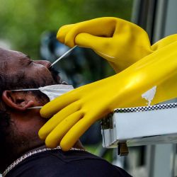 SRI LANKA. Un trabajador de salud (R) usa un hisopo para recolectar una muestra de prueba de coronavirus de un hombre en una unidad de prueba móvil durante un cierre nacional impuesto por el gobierno como medida preventiva contra el coronavirus COVID-19, en Colombo el 18 de abril de 2020. ( Foto de LAKRUWAN WANNIARACHCHI / AFP) | Foto:afp