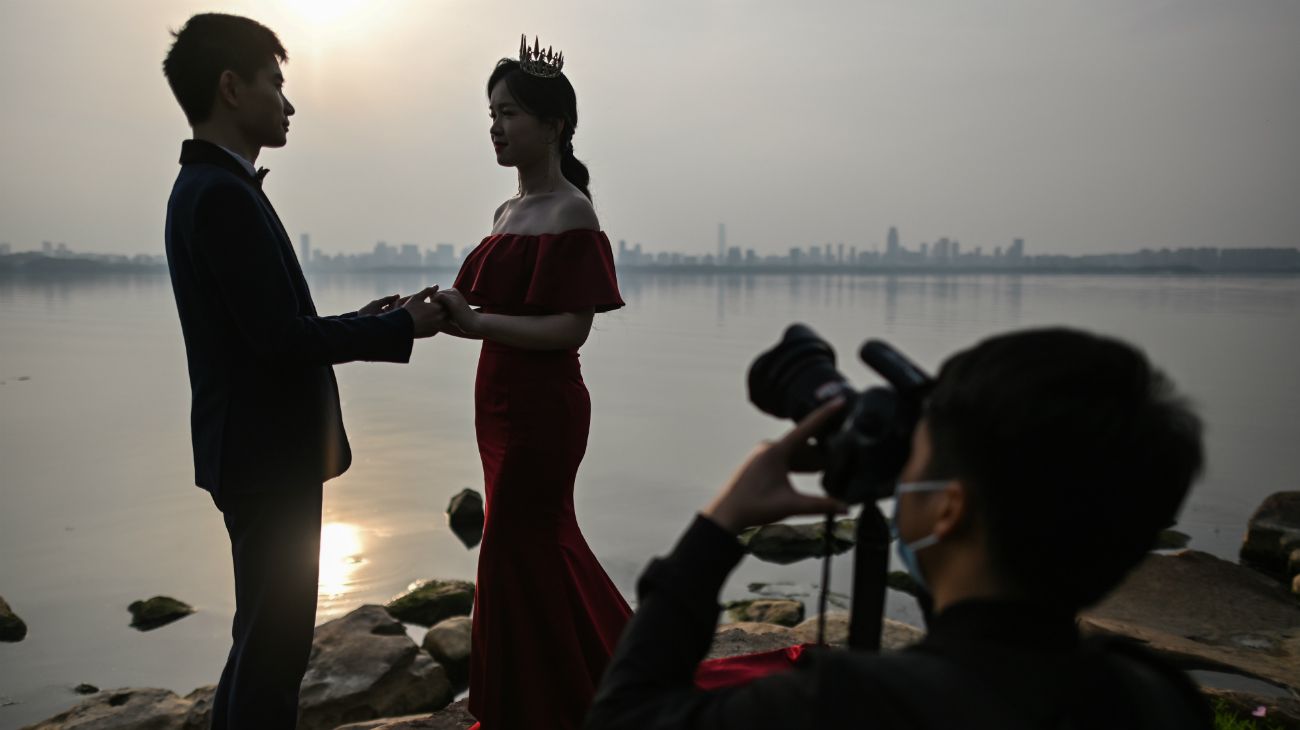 Una pareja de recién casados se fotografía junto al lago East en Wuhan, China, el 21 de abril