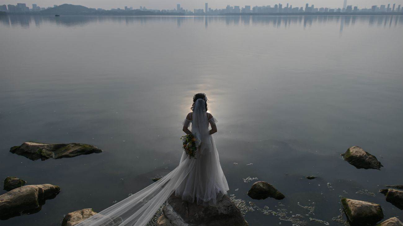 Una pareja de recién casados se fotografía junto al lago East en Wuhan, China, el 21 de abril