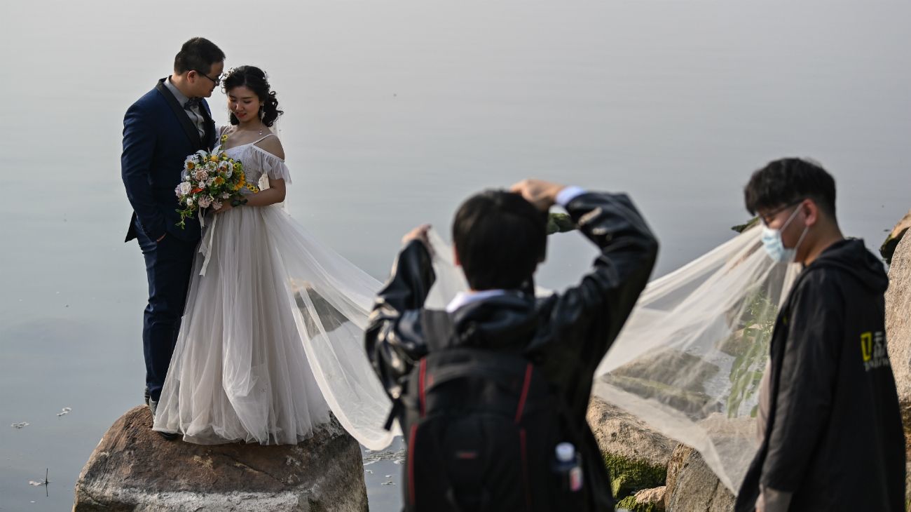 Una pareja de recién casados se fotografía junto al lago East en Wuhan, China, el 21 de abril