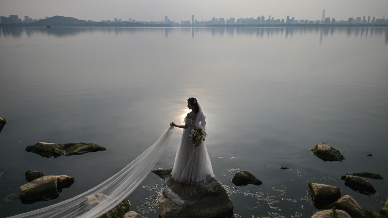 Una pareja de recién casados se fotografía junto al lago East en Wuhan, China, el 21 de abril