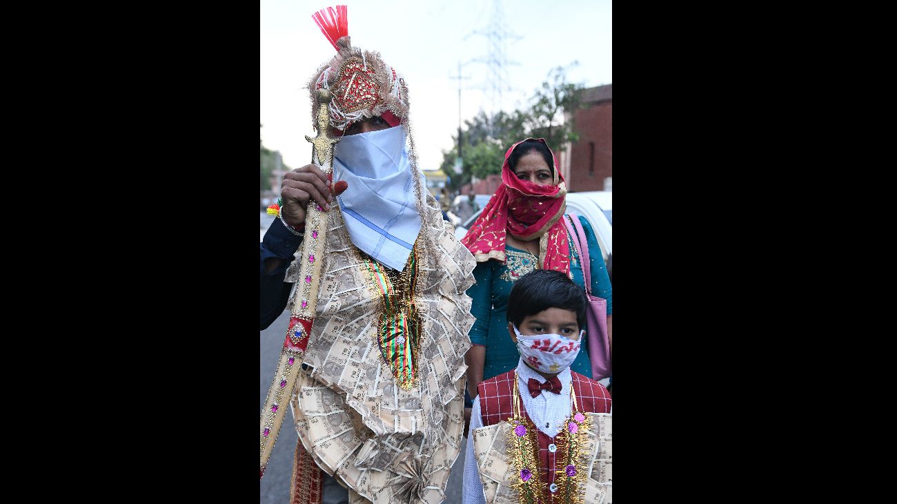 Un hombre sijista camina con su familia rumbo a su boda,  en las afueras de Amritsar, India, el 36 de abril