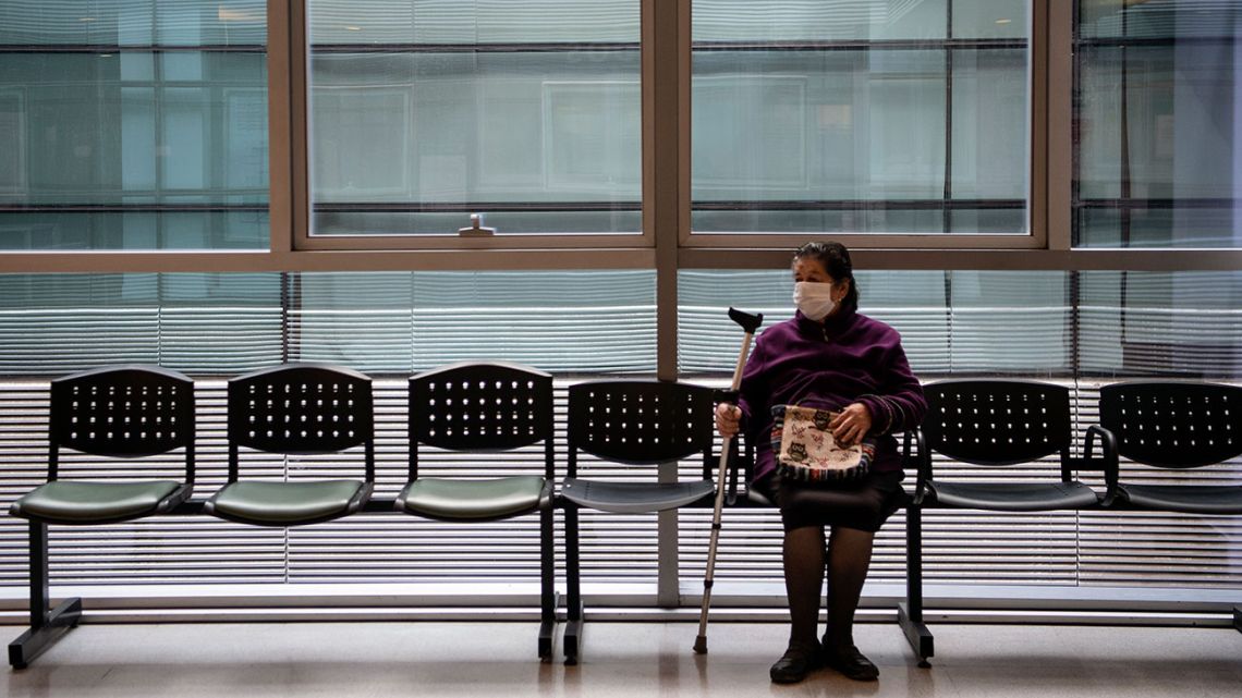 A woman wears a face mask as she waits for her turn at Del Carmen Hospital in Santiago, on April 27, 2020, amid the new Covid-19 coronavirus pandemic. 