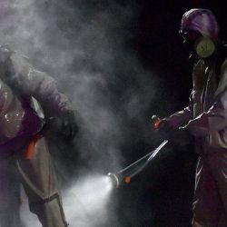 Los militares de Bielorrusia que usan desinfectante en aerosol de equipo de protección el uno al otro después de desinfectar un hospital en la ciudad de Zaslauye, en las afueras de Minsk, el 29 de abril de 2020, en medio de la pandemia de coronavirus. (Foto por Sergei GAPON / AFP) | Foto:AFP
