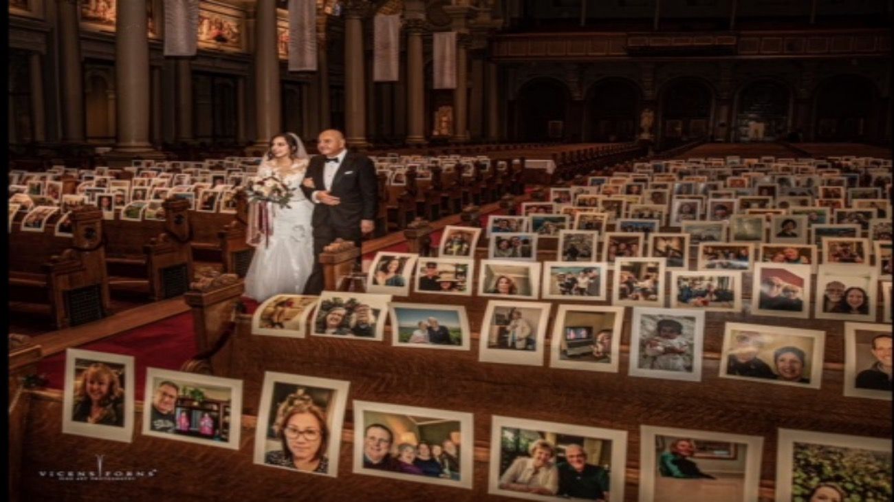 En San Francisco, la novia entra con el padrino, y las fotos de los invitados decoraron la iglesia. Ellos siguieron la boda por internet