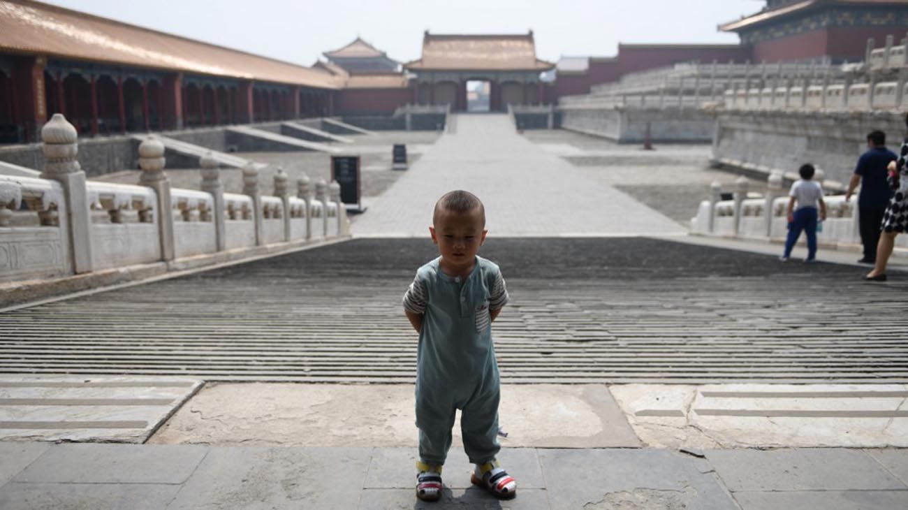 Los visitantes usan mascarillas como medida preventiva contra el Coronavirus, mientras caminan por la Ciudad Prohibida, el antiguo palacio de los emperadores de China.