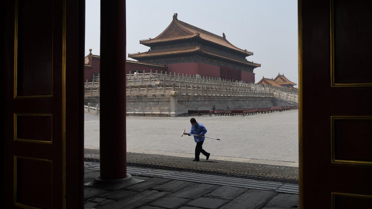 Los visitantes usan mascarillas como medida preventiva contra el Coronavirus, mientras caminan por la Ciudad Prohibida, el antiguo palacio de los emperadores de China.