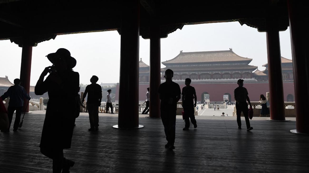 Los visitantes usan mascarillas como medida preventiva contra el Coronavirus, mientras caminan por la Ciudad Prohibida, el antiguo palacio de los emperadores de China.