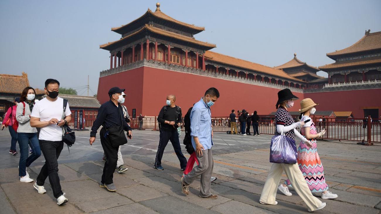 Los visitantes usan mascarillas como medida preventiva contra el Coronavirus, mientras caminan por la Ciudad Prohibida, el antiguo palacio de los emperadores de China.