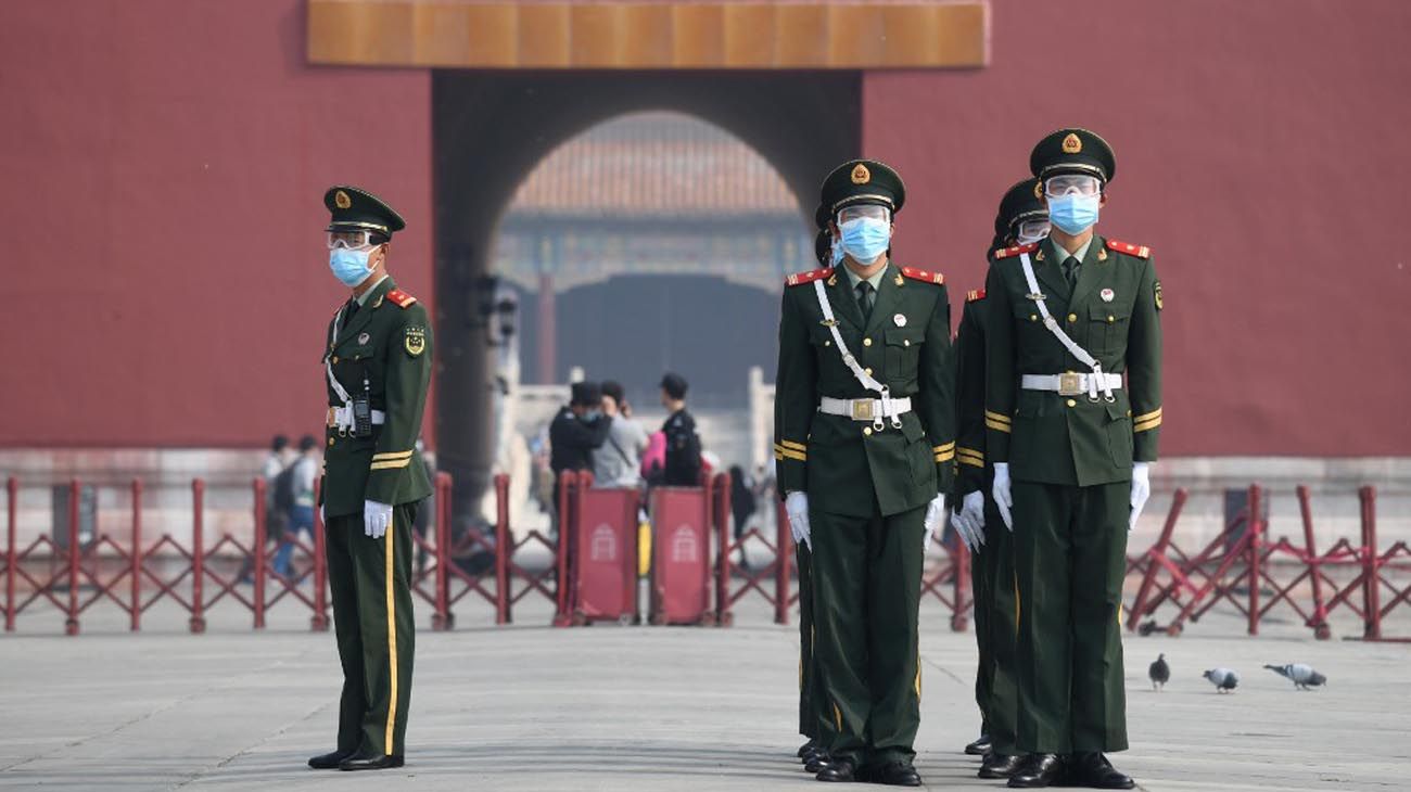 Los visitantes usan mascarillas como medida preventiva contra el Coronavirus, mientras caminan por la Ciudad Prohibida, el antiguo palacio de los emperadores de China.