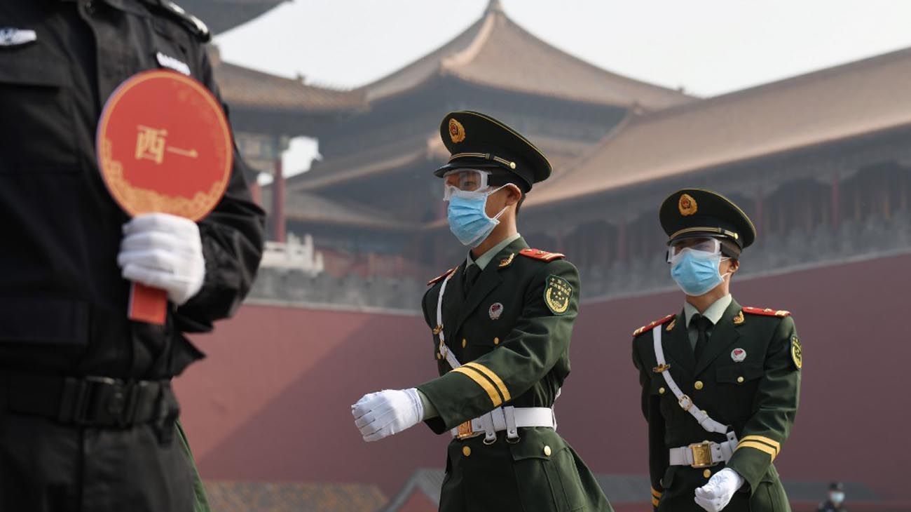 Los visitantes usan mascarillas como medida preventiva contra el Coronavirus, mientras caminan por la Ciudad Prohibida, el antiguo palacio de los emperadores de China.