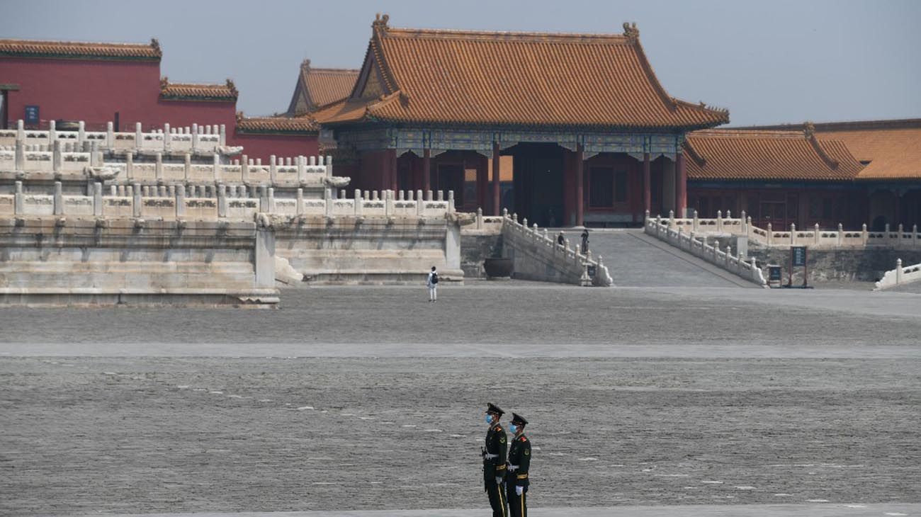 Los visitantes usan mascarillas como medida preventiva contra el Coronavirus, mientras caminan por la Ciudad Prohibida, el antiguo palacio de los emperadores de China.