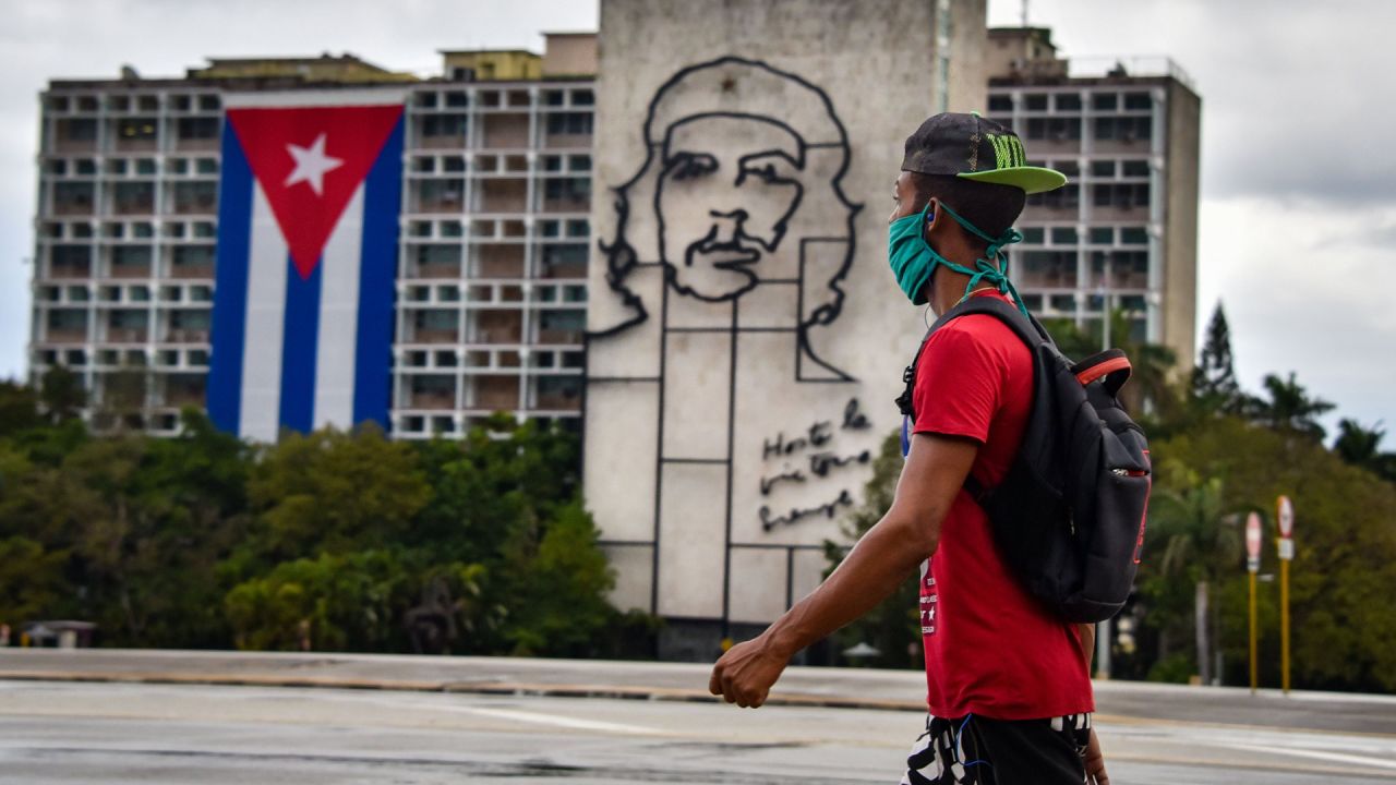 Un hombre camina frente al edificio del Ministerio del Interior con la imagen del legendario líder guerrillero Ernesto  | Foto:AFP