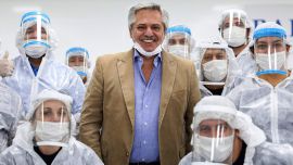 El Presidente Alberto Fernández (C) posando con trabajadores de una industria automotriz que ahora hace barbillas y gorras para luchar contra la propagación del nuevo coronavirus, COVID-19, en las afueras de Buenos Aires, Argentina, el 1 de mayo de 2020. FOTO AFP / Presidencia de Argentina / Esteban COLLAZO