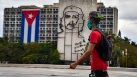 Un hombre camina frente al edificio del Ministerio del Interior con la imagen del legendario líder guerrillero Ernesto