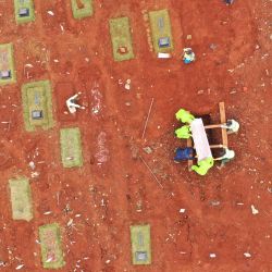 Indonesia. Esta fotografía aérea tomada el 2 de mayo de 2020 muestra sepultureros colocando un ataúd en el suelo en un cementerio designado para las víctimas del coronavirus COVID-19 en el cementerio Pondok Ranggon en Yakarta. (Foto por ADEK BERRY / AFP) | Foto:AFP