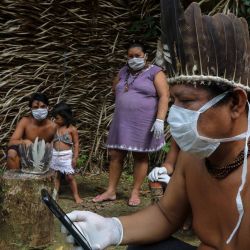 Se ve a los indígenas Satere-mawe usando un teléfono inteligente para contactar a un médico en el estado de Sao Paulo para recibir orientación médica en medio de la nueva pandemia de coronavirus COVID-19 en la comunidad Sahu-Ape, a 80 km de Manaus, estado de Amazonas, Brasil, el 5 de mayo. , 2020. - El estado brasileño de Amazonas, hogar de la mayoría de los pueblos indígenas del país, es una de las regiones más afectadas por la pandemia, con más de 500 muertes hasta la fecha según el ministerio de salud. (Foto por RICARDO OLIVEIRA / AFP) | Foto:AFP