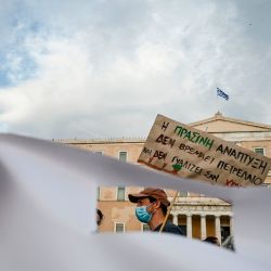Un manifestante sostiene una pancarta que dice 'El desarrollo verde no huele a petróleo y no brilla como el oro' mientras se manifiesta frente al Parlamento griego en Atenas el 4 de mayo de 2020, contra los planes del gobierno de revisar el petróleo en alta mar y -reglas de exploración de gas. (Foto por ARIS MESSINIS / AFP) | Foto:AFP