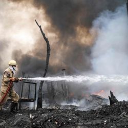 Un bombero rocía agua para controlar un incendio que se produjo en un almacén en Nueva Delhi el 6 de mayo de 2020. - No se reportó ninguna víctima después de que se produjera un gran incendio en un almacén de chatarra el 6 de mayo en la ciudad capital. (Foto por - / AFP) | Foto:AFP