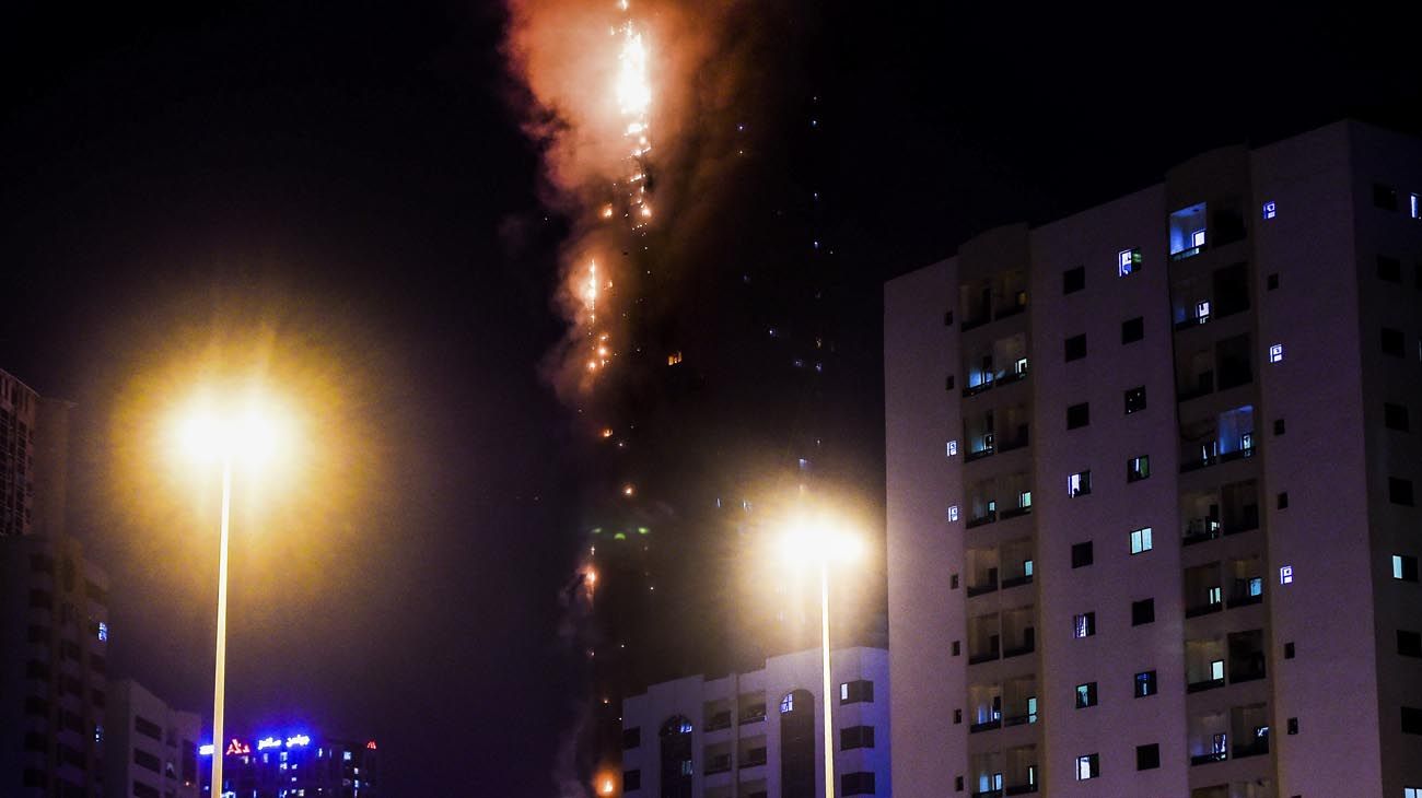  La gente se para en un puente y observa un incendio que se produce en una torre de 48 pisos en Sharjah, en los Emiratos Árabes.