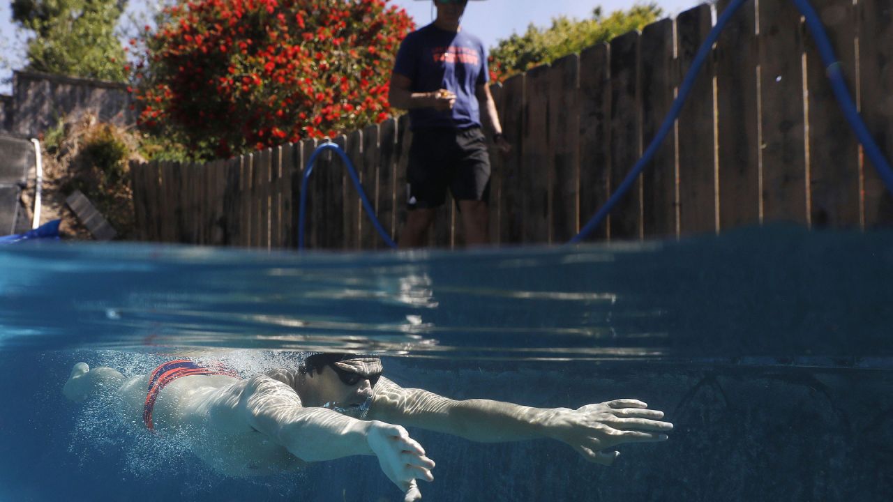 El nadador olímpico Michael Andrew es entrenado por su padre Peter mientras se entrena en una piscina residencial el 6 de mayo de 2020 en San Diego, California. Debido a la pandemia de COVID-19, muchos atletas de élite se han visto obligados a ajustar las ubicaciones y los regímenes de entrenamiento. Sean M. Haffey / Getty Images / AFP | Foto:AFP