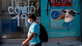 Una persona pasa junto a una farmacia donde se realizan pruebas de Covid-19 en la comuna de Recoleta, que fue puesta en cuarentena anoche para frenar la propagación del nuevo coronavirus COVID-19, en Santiago, el 6 de mayo de 2020. - Las autoridades de salud de Chile se endurecieron medidas obligatorias de confinamiento en Santiago el miércoles, ante un aumento en los casos de coronavirus, totalizando 23,048 infectados y 281 muertes en el país. (Foto por MARTIN BERNETTI / AFP)