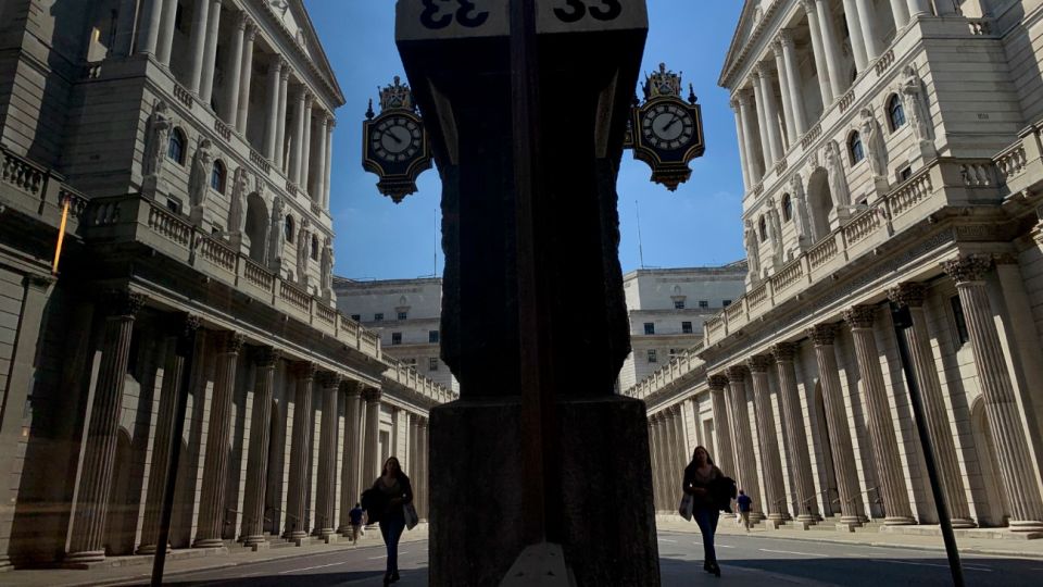 El reflejo de una ciudadana en una ventana mientras camina por el Banco de Inglaterra en Londres.