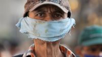 A man wears a piece of cloth as a face mask amid the spread of the new coronavirus at a street market in Caracas, Venezuela, Friday, April 10, 2020.