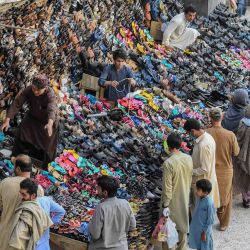 La gente compra zapatos cerca del puesto después de que el gobierno alivió el bloqueo nacional impuesto como medida preventiva contra el coronavirus COVID-19, en Quetta, el 9 de mayo de 2020. (Foto de Banaras KHAN / AFP) | Foto:AFP