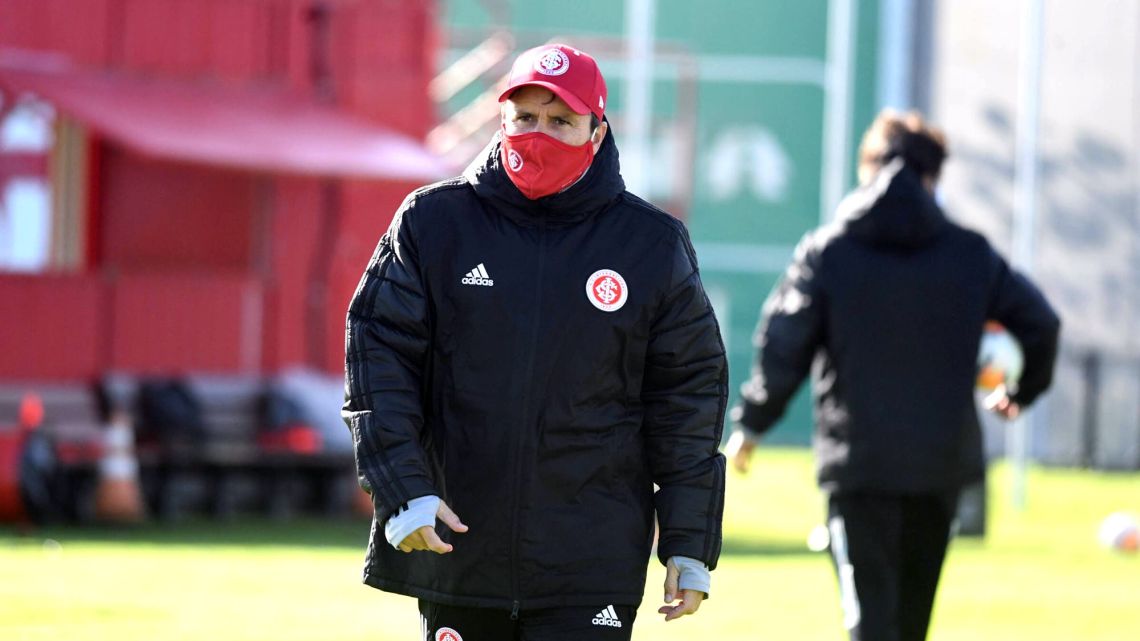 Internacional coach Eduardo Coudet oversees a training session in a face mask.