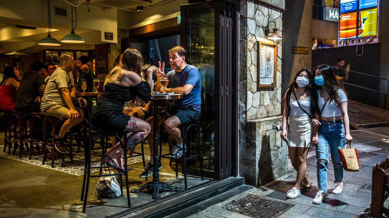 La gente se reúne para beber en un bar en Hong Kong el 9 de mayo de 2020. - Hong Kong suavizó las leyes de distanciamiento social el 8 de mayo que permitieron la apertura de algunos negocios, incluidos bares, cines y gimnasios con ciertas condiciones. (Foto por ISAAC LAWRENCE / AFP) | Foto:AFP
