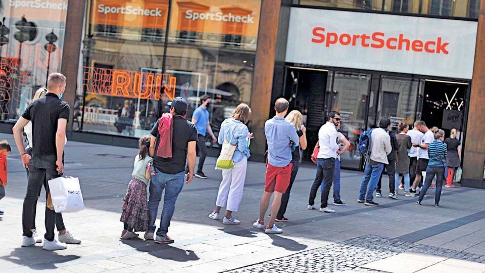 Distanciamiento social. Clientes en fila ante un local de productos deportivos en Munich.
