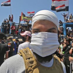 Un manifestante iraquí usa una máscara facial durante una manifestación antigubernamental en el puente Al-Jumhuriyah en la capital Bagdad, el 10 de mayo de 2020. - Hoy se reanudaron modestas manifestaciones antigubernamentales en algunas ciudades iraquíes, chocando con las fuerzas de seguridad y poniendo fin a meses de relativa calma pocos días después de que el gobierno del primer ministro Mustafa Kadhemi llegara al poder. (Foto por AHMAD AL-RUBAYE / AFP) | Foto:AFP