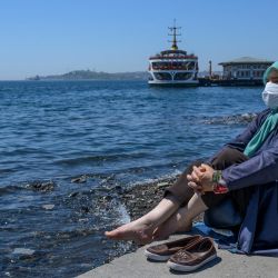 Una anciana con una máscara protectora mira el Bósforo el 10 de mayo de 2020, en Besiktas, Estambul, después de un mes y medio de restricciones de bloqueo destinadas a detener la propagación del nuevo coronavirus. (Foto por Bulent Kilic / AFP) | Foto:AFP