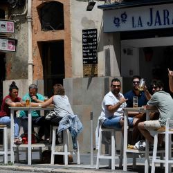 La gente se sienta afuera de un restaurante en Tarragona el 11 de mayo de 2020 mientras España se movía hacia aliviar su estricto bloqueo en ciertas regiones. - Uno de los países más afectados, España planea una transición gradual hasta finales de junio, con la mitad de los 47 millones de habitantes a los que se les permite socializar en grado limitado desde el lunes y restaurantes que ofrecen algún servicio al aire libre. (Foto por LLUIS GENE / AFP) | Foto:AFP