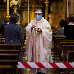 El sacerdote español Antonio Gómez, con una máscara facial y un escudo acrílico, da la comunión a los fieles en la Basílica de San Miguel en Palma de Mallorca el 11 de mayo de 2020, mientras España avanzaba para aliviar su estricto encierro en ciertas regiones. - Uno de los países más afectados, España planea una transición gradual hasta finales de junio, con la mitad de los 47 millones de habitantes a los que se les permite socializar en grado limitado desde el lunes y restaurantes que ofrecen algún servicio al aire libre. (Foto por JAIME REINA / AFP) | Foto:AFP