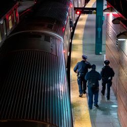 Los oficiales de la Policía de la Autoridad de Transporte de Metopolitan (MTA) caminan por la plataforma del metro para despejar a los vagones del metro de los pasajeros en la última parada en la estación de Coney Island en Brooklyn, Nueva York, el 6 de mayo de 2020. - El sistema de metro de la ciudad de Nueva York está suspendido entre 1 a.m. y 5 a.m.EDT a partir de esta noche para que los trenes puedan limpiarse para detener la propagación del coronavirus. (Foto de COREY SIPKIN / AFP) | Foto:AFP